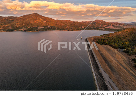 Aerial view of the Glenbawn Dam wall with surrounding water and mountain landscape in NSW Australia. Drone photograph captures the large dam structure, expansive reservoir and rugged regional scenery Aerial view of the Glenbawn Dam wall with surrounding water and mountain landscape in NSW Australia. Drone photograph captures the large dam structure, expansive reservoir and rugged regional scenery 139788456