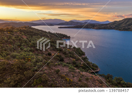 Aerial view of Glenbawn Dam at sunset in NSW Australia. Drone photograph captures calm dam waters, surrounding hills and colourful evening sky reflections from above. Scenic Australian inland Aerial view of Glenbawn Dam at sunset in NSW Australia. Drone photograph captures calm dam waters, surrounding hills and colourful evening sky reflections from above. Scenic Australian inland 139788457