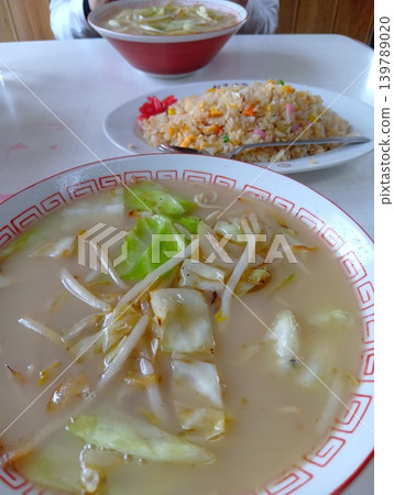 A scene of two people having lunch at a local Chinese restaurant: ramen and fried rice. 139789020