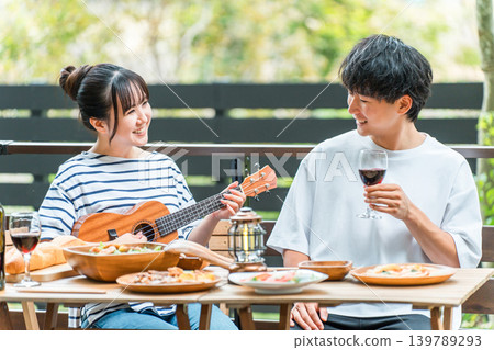 Young Asian men and women, couples enjoying a barbecue, home party, and glamping on a wooden deck. Young Asian men and women, couples enjoying a barbecue, home party, and glamping on a wooden deck. 139789293