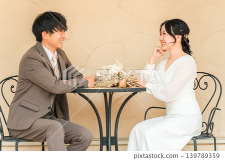 Couple talking while sitting at a table at a party Couple talking while sitting at a table at a party 139789359