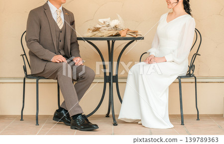 Couple talking while sitting at a table at a party Couple talking while sitting at a table at a party 139789363