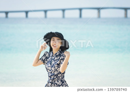 A woman wearing a straw hat at Yonaha Maehama Beach 139789740