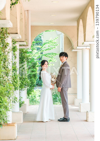 新郎新娘手捧花束，面對面站著（婚禮，新娘，情侶） 139790134