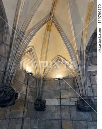 Architectural details of vaulted ceiling with stone carvings and lighting fixtures in Architectural details of vaulted ceiling with stone carvings and lighting fixtures in 139790170