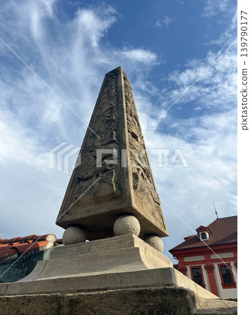 Ancient stone obelisk with intricate carvings and rounded base, set against a Ancient stone obelisk with intricate carvings and rounded base, set against a 139790177