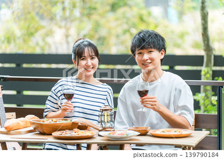 Couples dining on a wooden deck, terrace, or balcony (glamping/veranda camping) 139790184