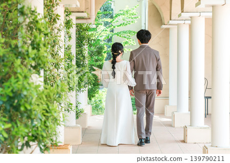 Back view of bride and groom walking into wedding hall (entrance, wedding) 139790211