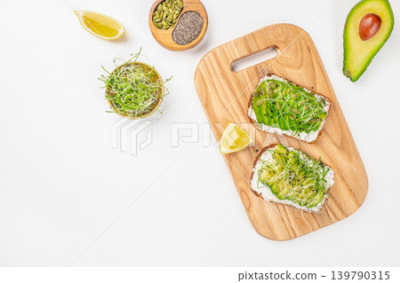 Avocado toast with sprouts and seeds on wooden board top view with copy space Avocado toast with sprouts and seeds on wooden board top view with copy space 139790315