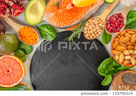 Healthy food background with salmon avocado nuts and superfoods around black stone board Healthy food background with salmon avocado nuts and superfoods around black stone board 139790324