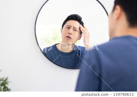 美妝圖片：一位男士正在對著鏡子進行護膚。 139790613