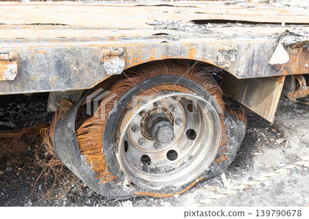The truck's materials are in tatters from the vehicle fire; the tires have burst, exposing the fibers inside. The truck's materials are in tatters from the vehicle fire; the tires have burst, exposing the fibers inside. 139790678