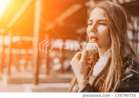 Woman ice cream summer young woman enjoying a pink ice cream cone outdoors during a warm golden sunset Woman ice cream summer young woman enjoying a pink ice cream cone outdoors during a warm golden sunset 139790758