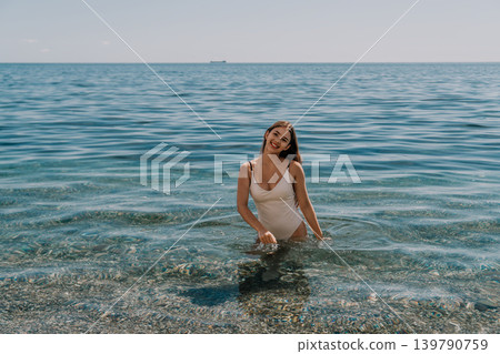 Woman swimsuit beach happy young woman wearing stylish swimwear while wading through the crystal clear blue sea water 139790759