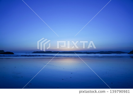 The tranquil seaside at dusk, bathed in a blue glow. The tranquil seaside at dusk, bathed in a blue glow. 139790981