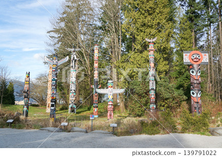 Canadian Indigenous totem poles line the forest. Canadian Indigenous totem poles line the forest. 139791022