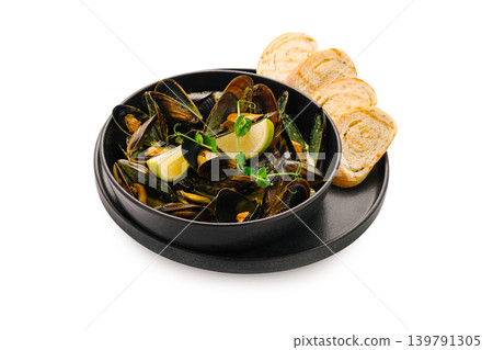 Mussels served with lemon and bread on a black plate Mussels served with lemon and bread on a black plate 139791305