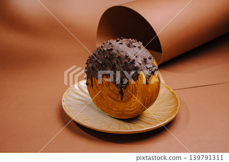 Baked bread roll covered in chocolate chips on a plate Baked bread roll covered in chocolate chips on a plate 139791311
