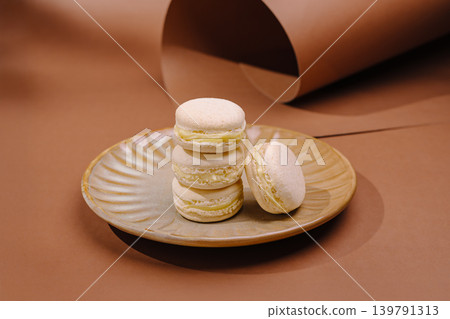 Macarons placed on a brown plate with a simple backdrop Macarons placed on a brown plate with a simple backdrop 139791313