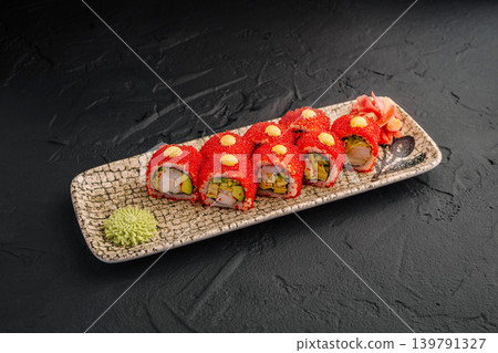 Sushi rolls on a decorative plate with wasabi and pickled ginger on the side 139791327