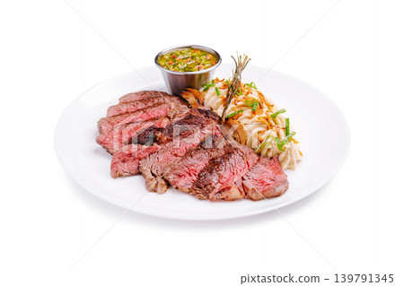 Sliced veal steak served with sauce and sides on a white plate during dinner Sliced veal steak served with sauce and sides on a white plate during dinner 139791345