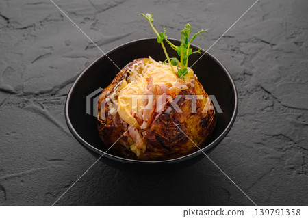 Baked potato stuffed with bacon, cheese, and fresh green garnish. Baked potato stuffed with bacon, cheese, and fresh green garnish. 139791358