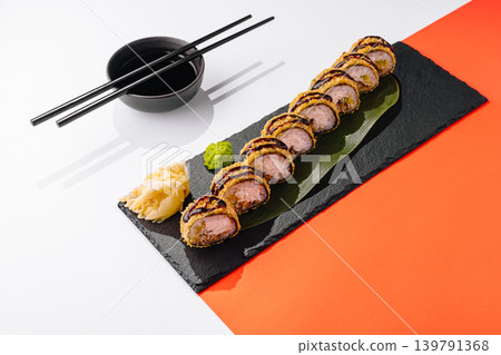 Sushi served on a black stone plate with chopsticks and condiments Sushi served on a black stone plate with chopsticks and condiments 139791368