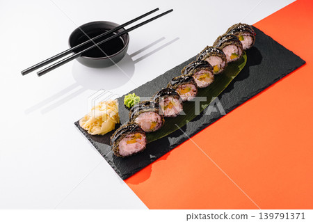 Sushi rolls presented on a black plate with wasabi and ginger on the side Sushi rolls presented on a black plate with wasabi and ginger on the side 139791371
