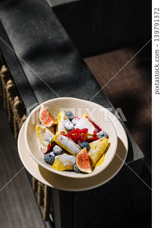 Delicious crepes with berries and fruit on a wooden table Delicious crepes with berries and fruit on a wooden table 139791372