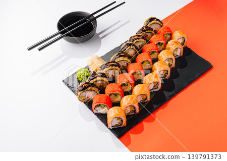 Sushi platter served on a black board with chopsticks and wasabi Sushi platter served on a black board with chopsticks and wasabi 139791373