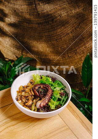 Fresh salad with octopus and grilled vegetables served on a wooden table Fresh salad with octopus and grilled vegetables served on a wooden table 139791415