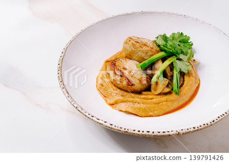 Delicious chicken patties served on a bed of hummus with greens Delicious chicken patties served on a bed of hummus with greens 139791426