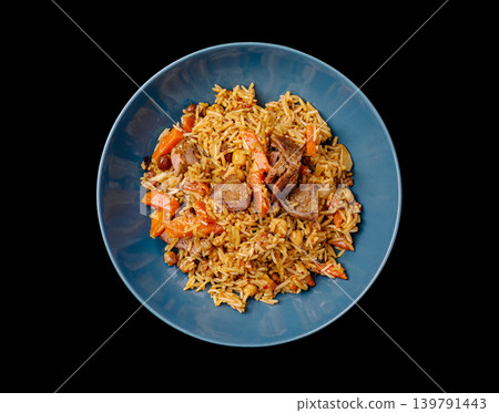 Plate of rice with meat and vegetables in a blue bowl on a black surface Plate of rice with meat and vegetables in a blue bowl on a black surface 139791443