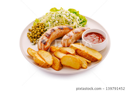 Sausages with salad, peas, and fried potatoes on a white plate Sausages with salad, peas, and fried potatoes on a white plate 139791452