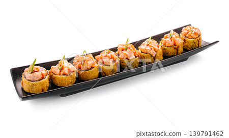 Sushi rolls served on a black plate with colorful toppings at a restaurant 139791462