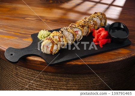 Sushi rolls served on a wooden board with wasabi and ginger on the side Sushi rolls served on a wooden board with wasabi and ginger on the side 139791465