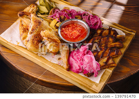 Grilled chicken and sides served on a wooden plate in a cozy setting Grilled chicken and sides served on a wooden plate in a cozy setting 139791470