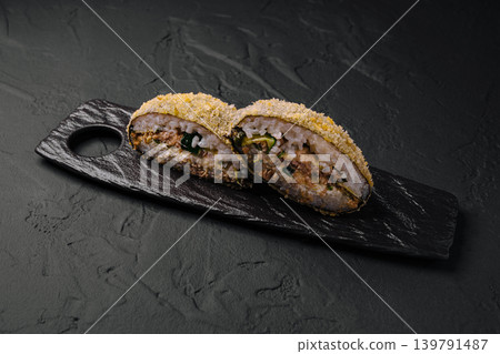 Sushi rolls presented on a black wooden tray ready for serving Sushi rolls presented on a black wooden tray ready for serving 139791487