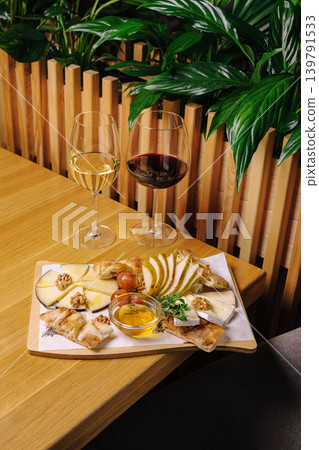 Cheese and wine pairing with fruit at a table in a dining setting Cheese and wine pairing with fruit at a table in a dining setting 139791533