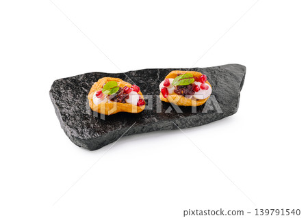 Delicious small canapes served on black stone plate with toppings Delicious small canapes served on black stone plate with toppings 139791540