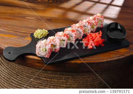 Sushi rolls served on a black wooden board with wasabi and ginger Sushi rolls served on a black wooden board with wasabi and ginger 139791571