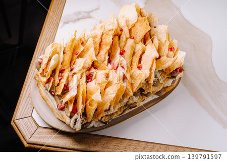 Delicious layered dessert served on a white platter with pomegranate Delicious layered dessert served on a white platter with pomegranate 139791597