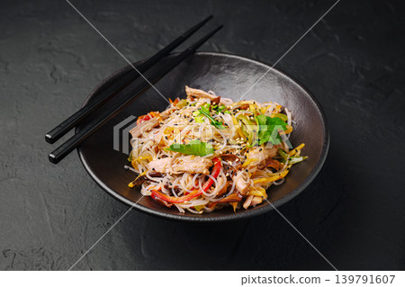 Delicious noodles served with chicken and vegetables in a black bowl Delicious noodles served with chicken and vegetables in a black bowl 139791607