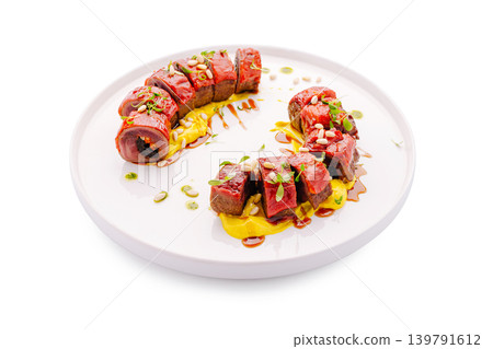 Delicious meat dish served on a white plate with sauces and toppings Delicious meat dish served on a white plate with sauces and toppings 139791612