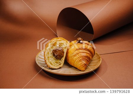 Croissant with filling on a plate beside brown paper Croissant with filling on a plate beside brown paper 139791628