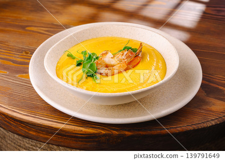 Delicious shrimp soup served in a white bowl on a wooden table Delicious shrimp soup served in a white bowl on a wooden table 139791649