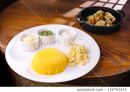 Tasty cornmeal dish with sauces on a wooden table Tasty cornmeal dish with sauces on a wooden table 139791655
