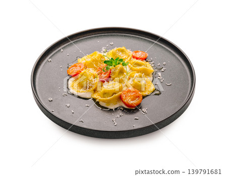 Ravioli with tomato and cheese served on a black plate in a simple setup Ravioli with tomato and cheese served on a black plate in a simple setup 139791681