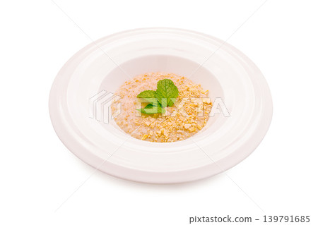 Delicious dish featuring oats with mint on a white plate in a simple setting Delicious dish featuring oats with mint on a white plate in a simple setting 139791685