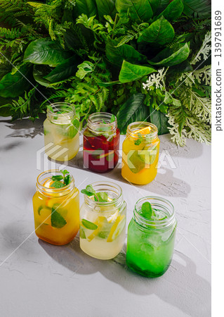 Colorful drinks in jars with fresh ingredients on a gray surface Colorful drinks in jars with fresh ingredients on a gray surface 139791689